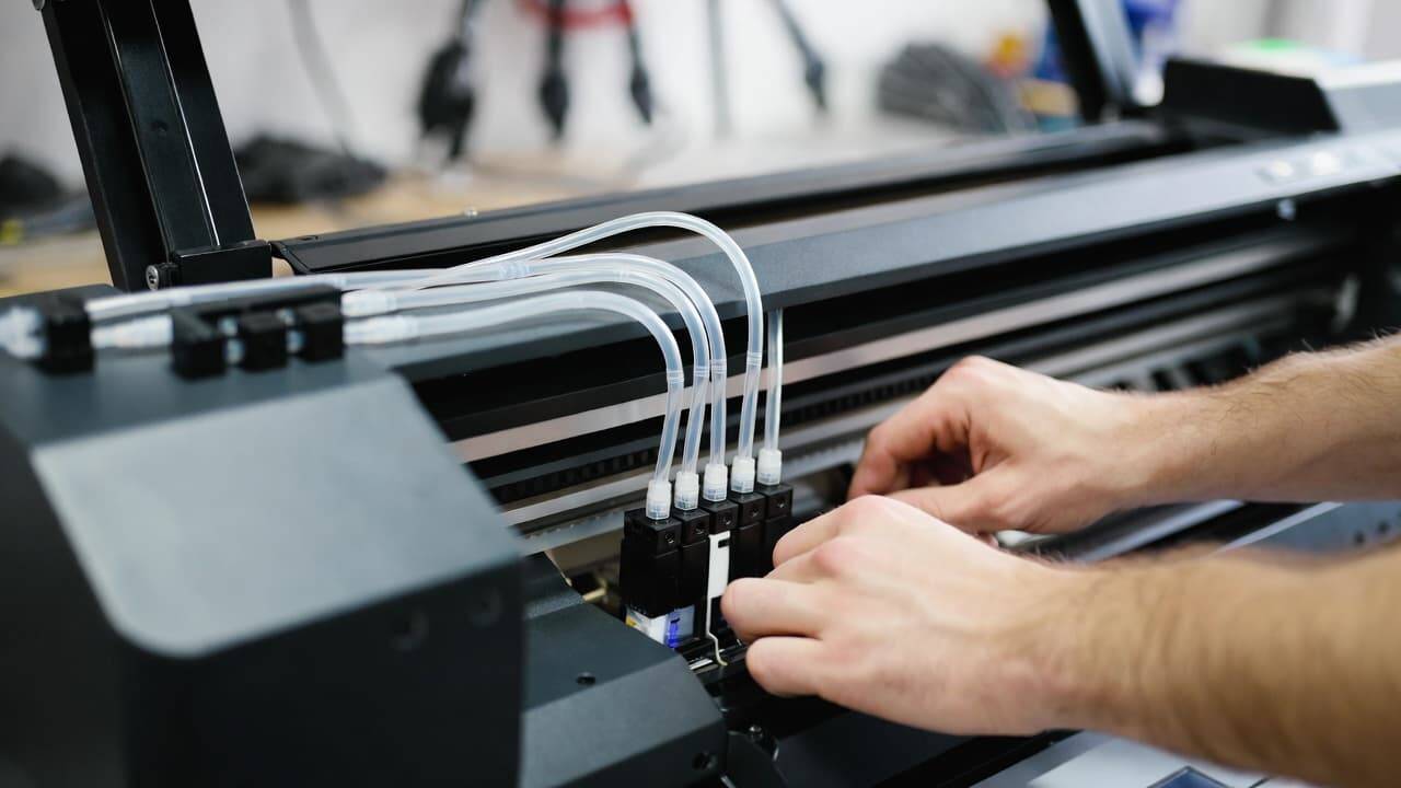 Close up of inkjet printer with DTF ink system installed and white ink cartridge