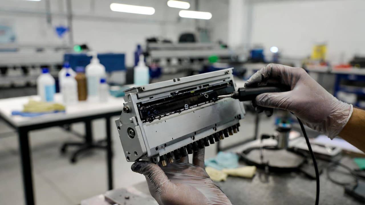 Technician cleaning and maintaining a DTF printer before trade-in inspection